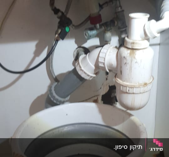 צנרת מתחת לכיור עם דלי מים
